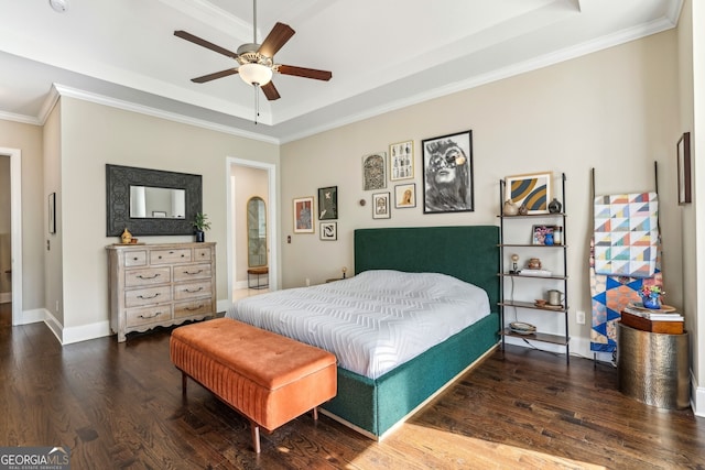 bedroom featuring ceiling fan, wood finished floors, baseboards, ornamental molding, and a raised ceiling