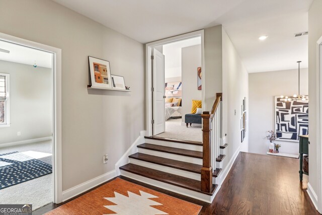 stairs featuring recessed lighting, wood finished floors, visible vents, baseboards, and an inviting chandelier