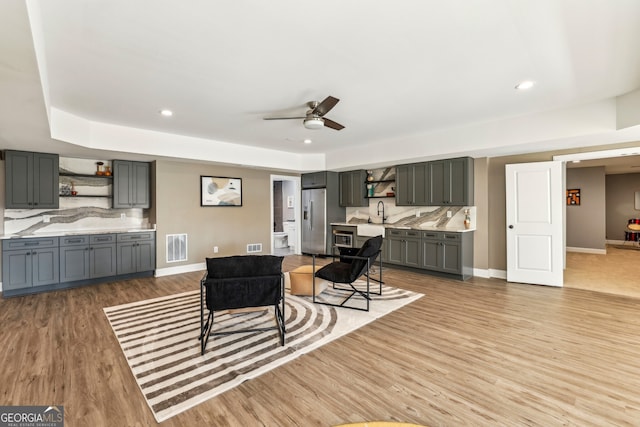 living room featuring light wood-style floors, recessed lighting, visible vents, and baseboards