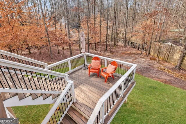 wooden terrace featuring a yard and fence