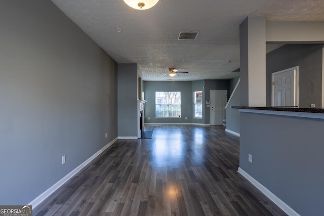 interior space featuring visible vents, dark wood finished floors, baseboards, and ceiling fan