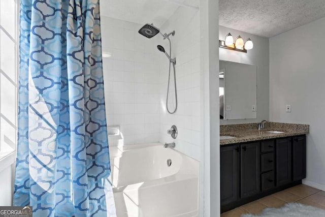 bathroom featuring double vanity, shower / bath combo with shower curtain, a sink, a textured ceiling, and tile patterned floors