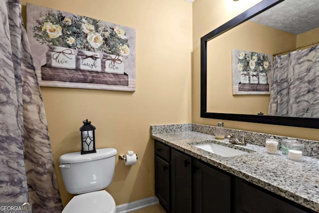 full bathroom with baseboards, a shower with shower curtain, toilet, a textured ceiling, and vanity