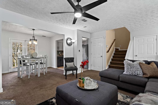 living room with carpet floors, visible vents, baseboards, stairs, and a ceiling fan