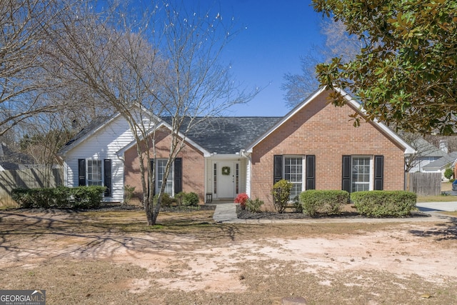 ranch-style house featuring fence and brick siding