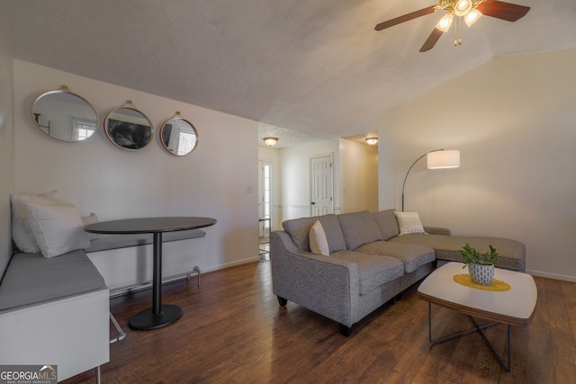 living room featuring lofted ceiling, hardwood / wood-style flooring, baseboards, and a textured ceiling