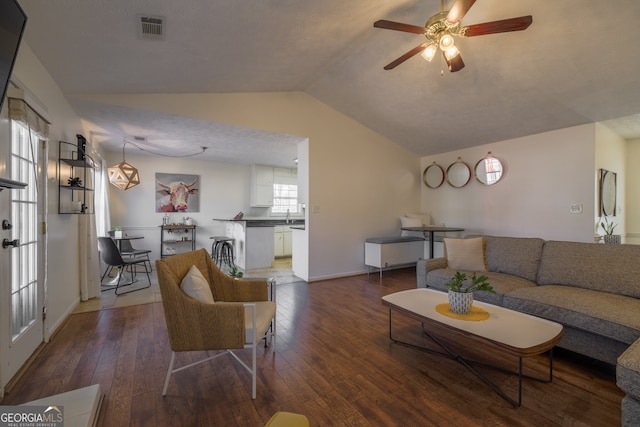 living room featuring a ceiling fan, lofted ceiling, visible vents, and hardwood / wood-style flooring