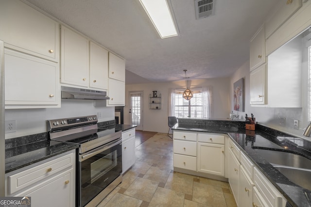 kitchen featuring visible vents, a sink, a peninsula, stainless steel range with electric stovetop, and under cabinet range hood