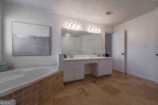 full bath with stone tile floors, a sink, visible vents, a bath, and double vanity