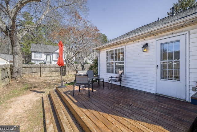 wooden deck featuring outdoor dining area and a fenced backyard