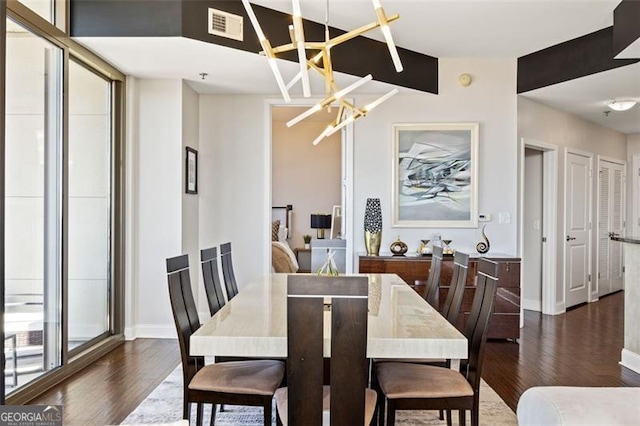 dining room featuring baseboards, dark wood-style flooring, visible vents, and an inviting chandelier