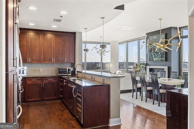 kitchen featuring an inviting chandelier, dark wood-style floors, stainless steel appliances, and a sink