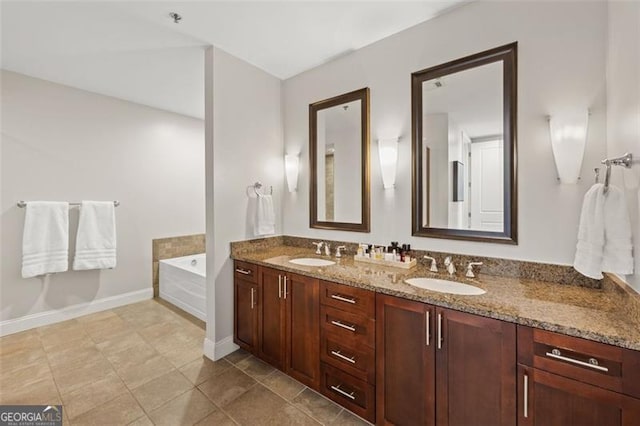 bathroom featuring double vanity, a garden tub, baseboards, and a sink