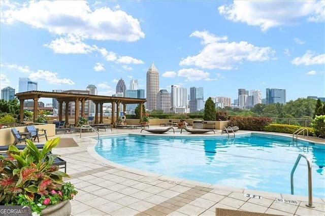 pool with a patio area and a city view