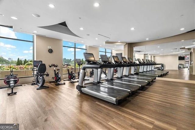 gym featuring a wealth of natural light, recessed lighting, and wood finished floors