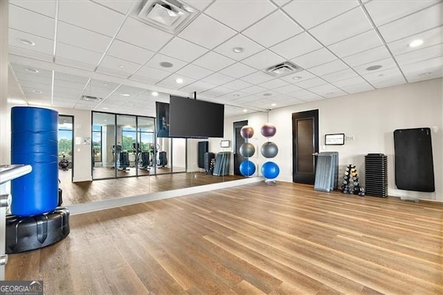 gym with visible vents, a drop ceiling, and wood finished floors