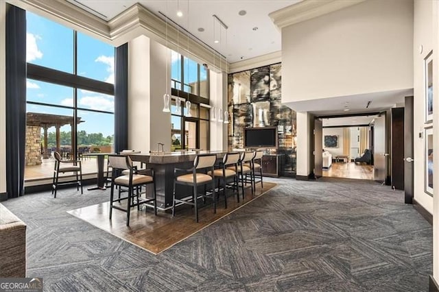 carpeted dining room with a towering ceiling and baseboards