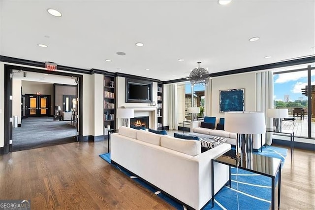 unfurnished living room with a healthy amount of sunlight, a lit fireplace, wood finished floors, and recessed lighting