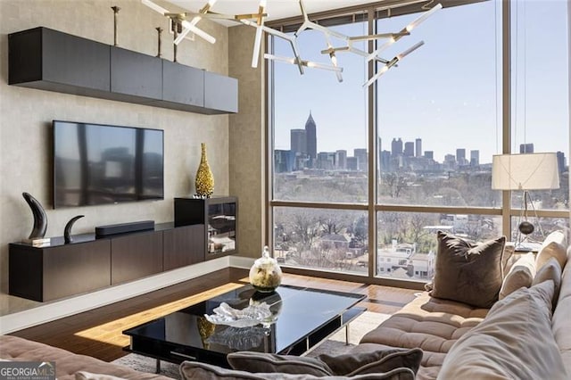 living room featuring a wall of windows, wood finished floors, and an inviting chandelier