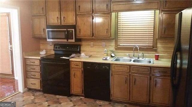 kitchen featuring black appliances, a sink, and light countertops