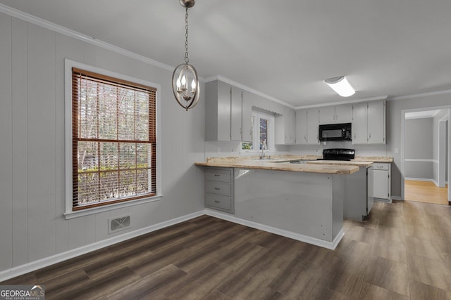 kitchen featuring a peninsula, a sink, visible vents, light countertops, and black appliances