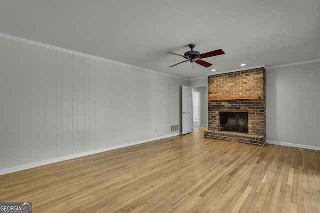 unfurnished living room featuring hardwood / wood-style flooring, a fireplace, visible vents, and a ceiling fan