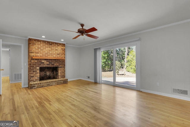 unfurnished living room featuring ornamental molding, a brick fireplace, visible vents, and light wood-style floors