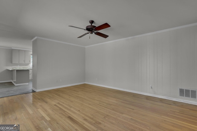 unfurnished living room with light wood finished floors, baseboards, visible vents, a ceiling fan, and ornamental molding