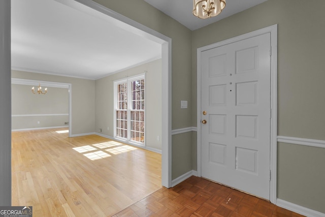 entryway featuring parquet floors, baseboards, and an inviting chandelier