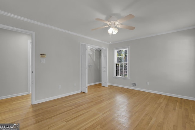 unfurnished bedroom featuring crown molding, a closet, visible vents, light wood-style flooring, and baseboards