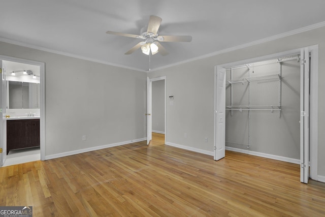 unfurnished bedroom featuring baseboards, light wood finished floors, a closet, and crown molding