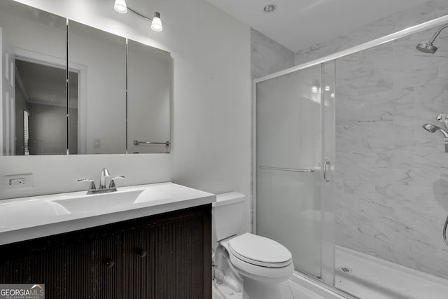 full bath featuring toilet, a shower stall, and vanity