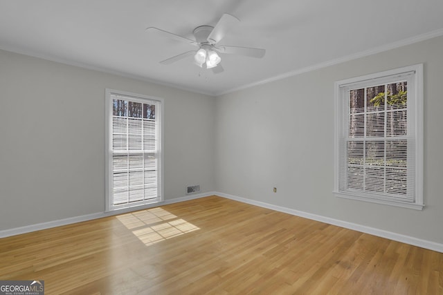 unfurnished room with a wealth of natural light, light wood-type flooring, and visible vents