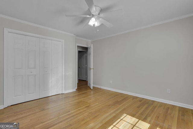 unfurnished bedroom featuring ornamental molding, a closet, light wood-style flooring, and baseboards