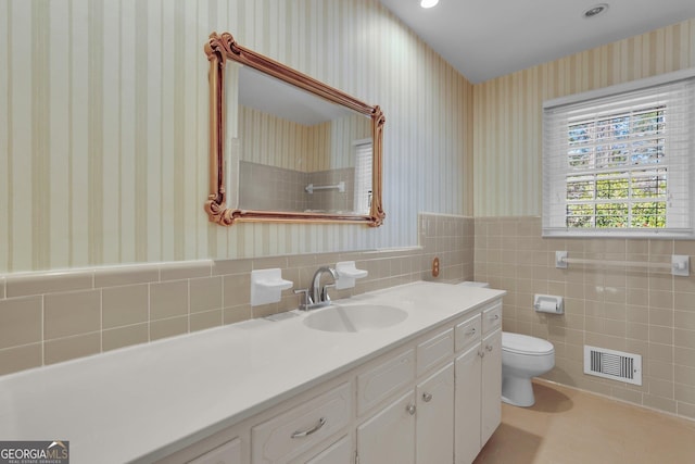 bathroom with a wainscoted wall, toilet, visible vents, and wallpapered walls