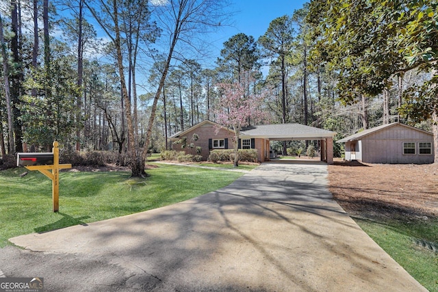 view of front of home featuring driveway, a front lawn, an attached carport, and brick siding