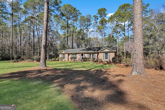 single story home with brick siding and a front yard