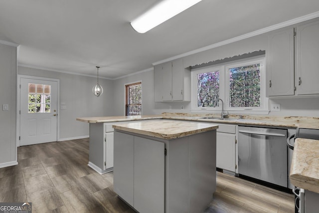 kitchen with wood finished floors, a sink, stainless steel dishwasher, a center island, and crown molding