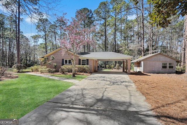 view of front of home with brick siding, driveway, a front lawn, and an attached carport