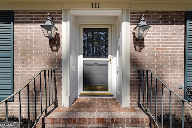 entrance to property featuring brick siding