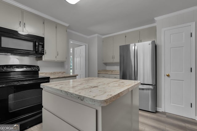 kitchen with light countertops, light wood-type flooring, a center island, black appliances, and crown molding