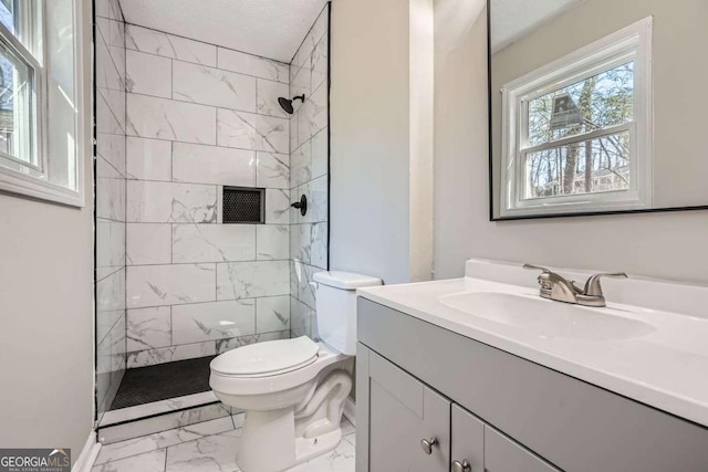 full bath featuring marble finish floor, tiled shower, vanity, and toilet