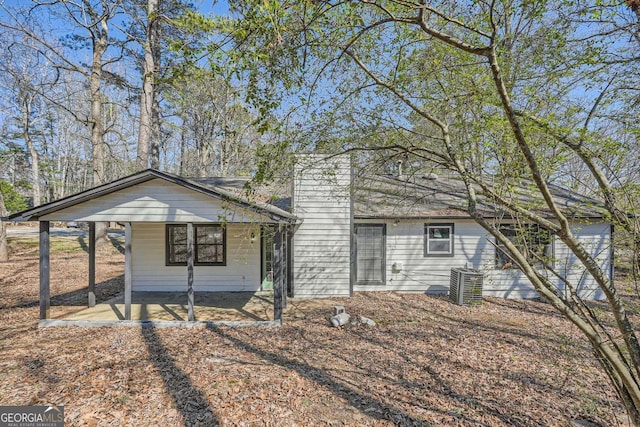 view of front of home with a carport and central air condition unit