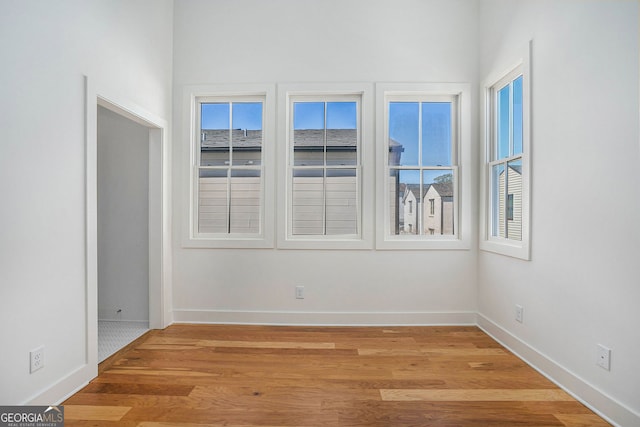 spare room featuring light wood finished floors and baseboards