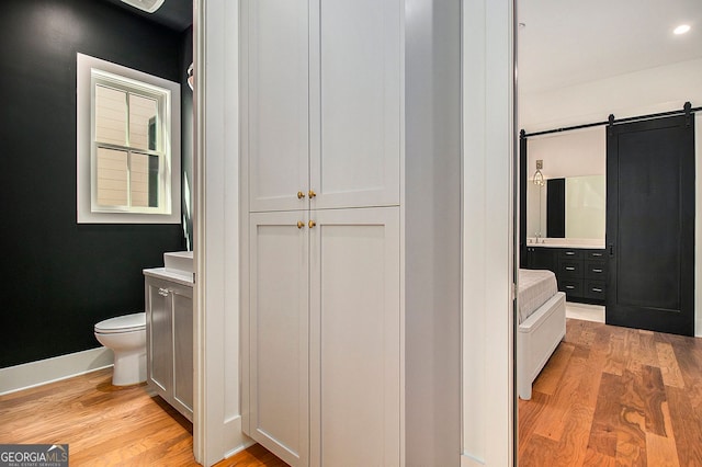 bathroom featuring vanity, toilet, and wood finished floors