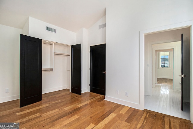 unfurnished bedroom featuring visible vents, light wood-style flooring, and baseboards