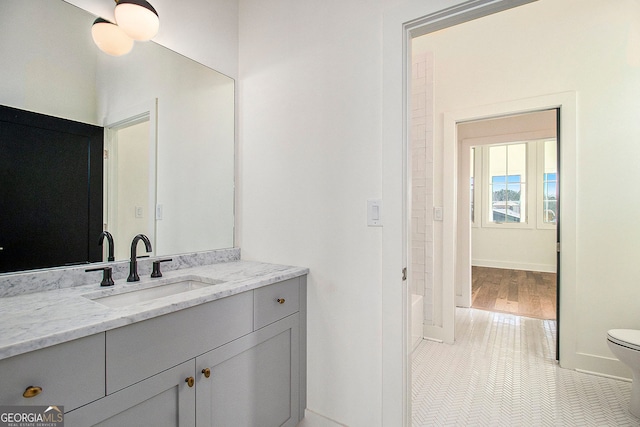 bathroom with baseboards, vanity, toilet, and tile patterned floors