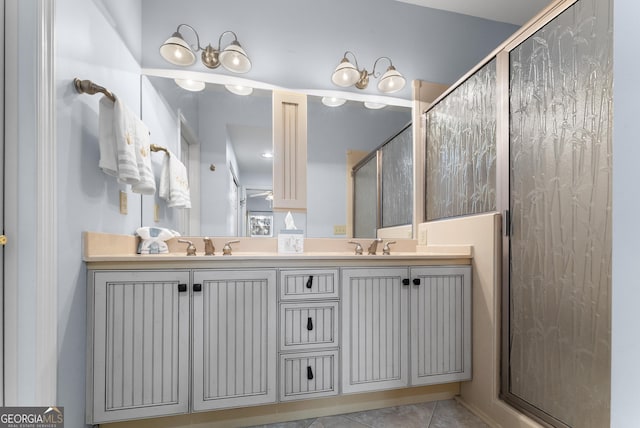 bathroom featuring double vanity, a shower stall, a sink, and tile patterned floors