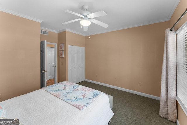 bedroom with baseboards, visible vents, ornamental molding, dark colored carpet, and a closet