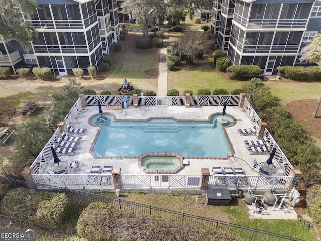 community pool with a patio area, a fenced backyard, and a hot tub